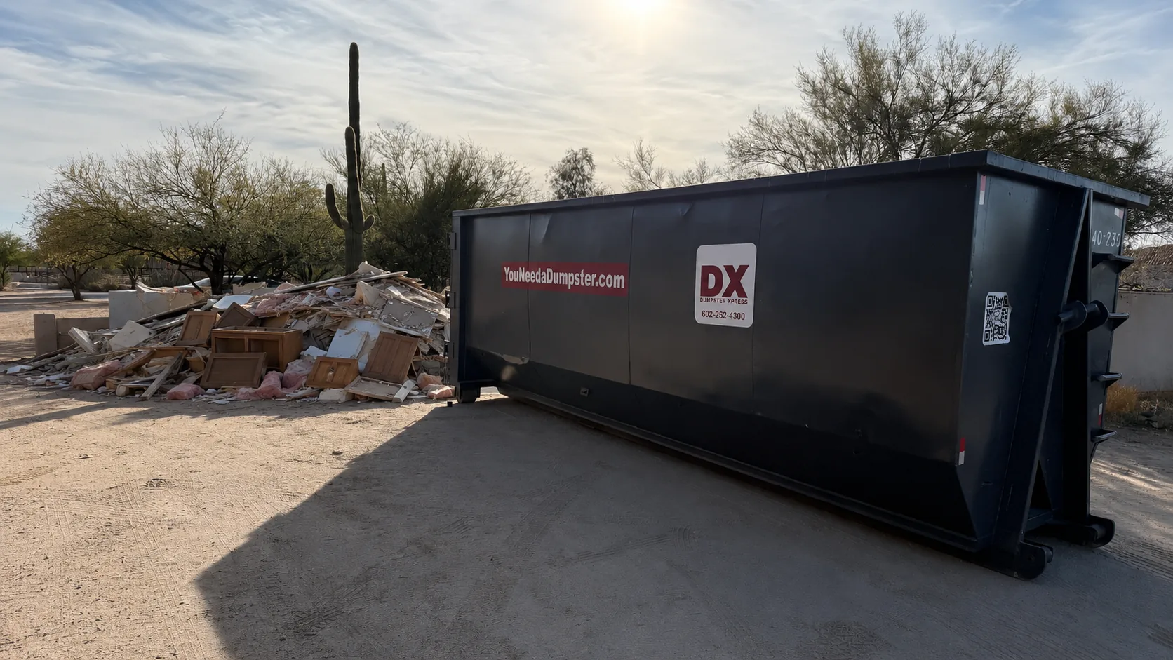 Dumpstr Xpress roll-off dumpster beside home remodeling debris in Phoenix