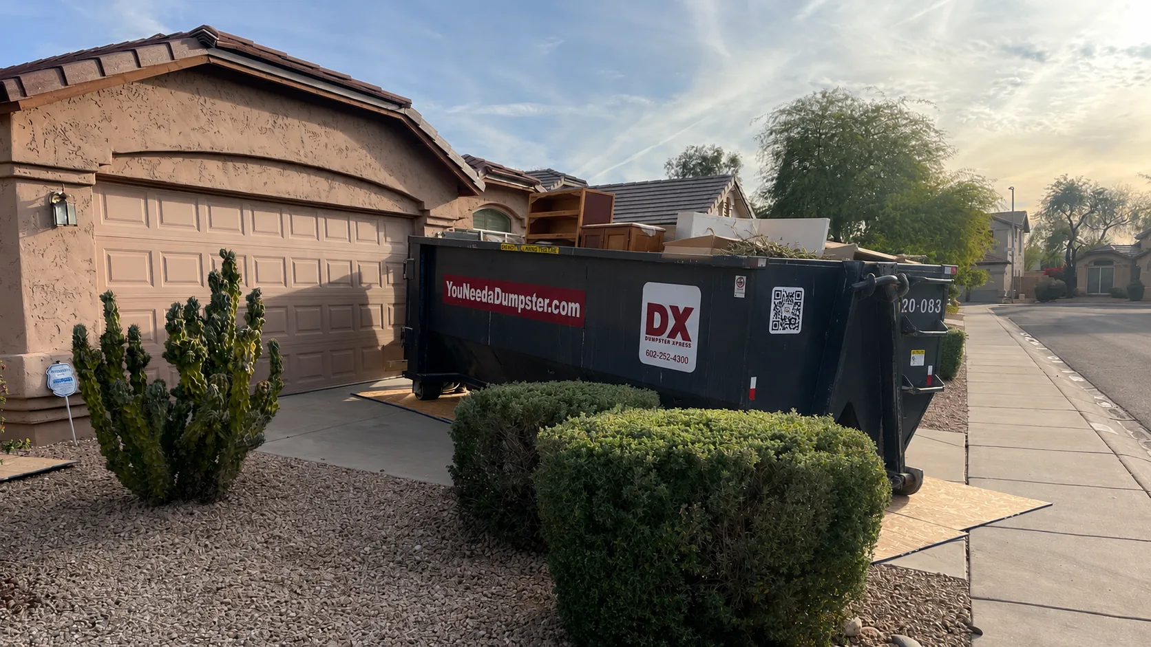 Dumpstr Xpress residential dumpster loaded with furniture and household debris at a Phoenix home